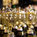 The Oscars stage with golden statuettes and YouTube logo overlay, representing the awards show streaming exclusively on YouTube starting in 2029